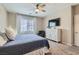 Bright bedroom featuring a queen-sized bed, modern ceiling fan and a large dresser at 8490 Classique Ave # 101, Las Vegas, NV 89178