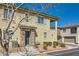 Townhouse with private balcony, stone accents, and neat landscaping, set against a clear sky at 8490 Classique Ave # 101, Las Vegas, NV 89178