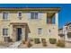 Townhouse featuring a private balcony, stone accents, and blue shutters, enhancing curb appeal at 8490 Classique Ave # 101, Las Vegas, NV 89178