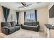Cozy living room with plush gray seating, neutral walls, bright windows, and modern ceiling fan at 8490 Classique Ave # 101, Las Vegas, NV 89178