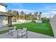 Backyard putting green, a perfect leisure area with chairs and palms in view at 8717 Kingship Ct, Las Vegas, NV 89129