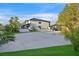 A wide driveway and grassy backyard are accompanied by palm trees, creating a serene outdoor setting at 8717 Kingship Ct, Las Vegas, NV 89129