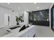 A modern living room with a black marble accent wall and bright white walls at 8717 Kingship Ct, Las Vegas, NV 89129