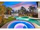 Relaxing backyard featuring a pool, hot tub, lounge area, and lush landscaping at 8717 Kingship Ct, Las Vegas, NV 89129