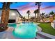 Beautiful backyard with a large pool, spa, sun loungers, and mature palm trees at 8717 Kingship Ct, Las Vegas, NV 89129