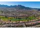 Panoramic aerial view of a residential area with a golf course and picturesque mountain scenery at 8812 Stoney Point Dr, Las Vegas, NV 89134