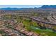 Wide aerial view of a residential community built around a golf course with scenic mountain views at 8812 Stoney Point Dr, Las Vegas, NV 89134