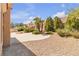 Landscaped backyard featuring mature trees, green shrubs, rock features, and a concrete patio, offering a serene outdoor space at 8812 Stoney Point Dr, Las Vegas, NV 89134