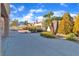 Well maintained backyard featuring mature trees, green shrubs, rock features, and a walkway around the home at 8812 Stoney Point Dr, Las Vegas, NV 89134