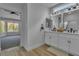 Bathroom with double vanity, wood-look floor, and doorway to the bedroom at 8812 Stoney Point Dr, Las Vegas, NV 89134