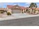 Charming single-story home with a red tile roof, desert landscaping, and a two-car garage at 8812 Stoney Point Dr, Las Vegas, NV 89134