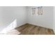 Cozy bedroom with bright white walls, wood-look flooring, and a sun-filled window at 887 W Carey Ave, North Las Vegas, NV 89030