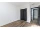 Bedroom featuring wood floors, white walls, and closet with dark double doors at 887 W Carey Ave, North Las Vegas, NV 89030