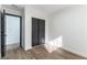 Clean bedroom featuring wood-look floors, white walls, and closet with dark sliding doors at 887 W Carey Ave, North Las Vegas, NV 89030