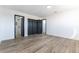 Bedroom featuring wood flooring and closet with dark double doors, leading to a bath at 887 W Carey Ave, North Las Vegas, NV 89030