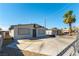 Single story home boasting a neutral toned exterior, mature landscaping and a large concrete driveway at 887 W Carey Ave, North Las Vegas, NV 89030