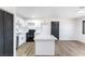 Updated kitchen featuring white cabinets, stainless steel appliances, an island, and wood-look floors at 887 W Carey Ave, North Las Vegas, NV 89030
