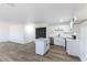 Kitchen featuring white cabinets, stainless steel appliances, a center island and wood-look floors at 887 W Carey Ave, North Las Vegas, NV 89030