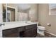 Bathroom features modern fixtures, a large mirror, and a vanity with storage, toilet and shower with glass door at 922 Harbor Ave, Henderson, NV 89002