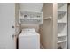 Functional laundry area with a modern washer, overhead storage, and convenient shelving, designed for organization at 10001 Peace Way # 1321, Las Vegas, NV 89147