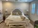 Elegant bedroom with a tufted headboard, decorative pillows, and plantation shutters, exuding a peaceful ambiance at 10398 Addie De Mar Ln, Las Vegas, NV 89135