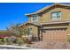Attractive home with a two-car garage, complemented by green landscaping and a clear blue sky at 10398 Addie De Mar Ln, Las Vegas, NV 89135