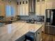 Modern kitchen featuring a large island, stainless steel appliances, and decorative backsplash tiles at 10398 Addie De Mar Ln, Las Vegas, NV 89135