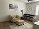 Relaxing living room featuring a tufted armchair, ottoman, and elegant decor at 10398 Addie De Mar Ln, Las Vegas, NV 89135