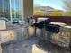 Outdoor kitchen area featuring a grill, stainless steel storage, and a stone counter at 10398 Addie De Mar Ln, Las Vegas, NV 89135