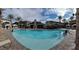 Large community pool surrounded by palm trees, lounge chairs, and cabanas for relaxation at 10398 Addie De Mar Ln, Las Vegas, NV 89135