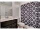 Compact bathroom with a vanity, toilet, and shower with a patterned curtain at 105 Campbelltown Ave, Henderson, NV 89015