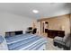 Bright bedroom with striped bedding, an office space, and a stylish grey chair and carpeted floors at 105 Campbelltown Ave, Henderson, NV 89015