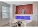 Stylish living area with a unique fireplace, comfortable seating, and natural light from the window at 105 Campbelltown Ave, Henderson, NV 89015