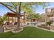 Landscaped backyard with gazebo, artificial turf, desert landscaping, and swimming pool at 10748 Aldrovandi Dr, Las Vegas, NV 89141