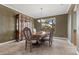 Formal dining room with elegant wood furniture, neutral walls, tile flooring, and a large window at 10748 Aldrovandi Dr, Las Vegas, NV 89141