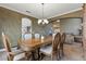 Formal dining room with elegant wood furniture, neutral walls, tile flooring, and open to the living room at 10748 Aldrovandi Dr, Las Vegas, NV 89141