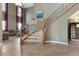 Inviting entryway with tile floors, carpeted staircase, and elegant wrought iron railing at 10748 Aldrovandi Dr, Las Vegas, NV 89141