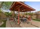 Covered gazebo in backyard features seating and a cozy fire pit at 10748 Aldrovandi Dr, Las Vegas, NV 89141