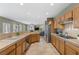 Large kitchen featuring oak cabinets, stainless appliances, tile flooring, and a view into the Gathering room at 10748 Aldrovandi Dr, Las Vegas, NV 89141