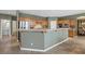 Open kitchen with oak cabinets, tile flooring, and a breakfast bar overlooking the dining room at 10748 Aldrovandi Dr, Las Vegas, NV 89141