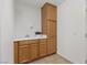 A modern laundry room offering cabinetry, tile floors, sink and dedicated storage at 10748 Aldrovandi Dr, Las Vegas, NV 89141