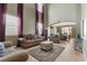 Bright living room with high ceilings, neutral walls, tile flooring, and stylish, comfortable furniture at 10748 Aldrovandi Dr, Las Vegas, NV 89141