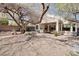 The backyard with mature trees and covered patio offers space for relaxation and outdoor enjoyment at 10847 Intro Ave, Las Vegas, NV 89135