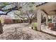 Backyard area with mature trees, gravel, covered patio, seating and manicured landscaping at 10847 Intro Ave, Las Vegas, NV 89135
