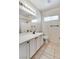 A well-lit bathroom features a single sink vanity, tile flooring, and a shower with dark hardware at 10847 Intro Ave, Las Vegas, NV 89135