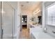 Bright bathroom with dual sinks, soaking tub, glass shower and a view to the main bedroom at 10847 Intro Ave, Las Vegas, NV 89135