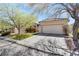 Inviting front exterior with manicured lawn, mature trees, and a two-car garage at 10847 Intro Ave, Las Vegas, NV 89135