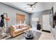 Comfortable living room features a ceiling fan, a neutral sofa, stylish decor, and bright window at 10847 Intro Ave, Las Vegas, NV 89135