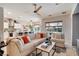Open-concept living room with comfortable seating, a ceiling fan, and a seamless flow into the kitchen at 10847 Intro Ave, Las Vegas, NV 89135