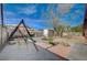 A backyard featuring a play set, trees, and rock landscaping at 1113 Date St, Las Vegas, NV 89108